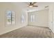 Large bedroom featuring arched windows, plantation shutters, plush carpeting and modern ceiling fan at 2372 Perrysburg Dr, Henderson, NV 89044
