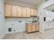 Functional laundry room with wooden cabinets, granite countertop, and utility sink at 2372 Perrysburg Dr, Henderson, NV 89044
