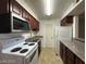 Bright kitchen featuring white appliances, dark wood cabinets and a gray countertop at 2606 S Durango Dr # 172, Las Vegas, NV 89117