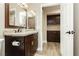 Tasteful bathroom featuring dark wood cabinets, granite countertop and a mirror with views of the adjacent room at 2705 Tumble Brook Dr, Las Vegas, NV 89134