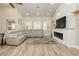Bright living room with a fireplace, modern wood flooring, neutral walls, and a large sectional sofa at 2705 Tumble Brook Dr, Las Vegas, NV 89134