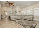 Spacious living area featuring wood-look floors, a comfortable sectional, and a ceiling fan at 2705 Tumble Brook Dr, Las Vegas, NV 89134