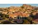 Sprawling single-story home with a tile roof and a large patio, set against a backdrop of majestic mountains at 2742 Darby Falls Dr, Las Vegas, NV 89134