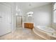 Well-lit bathroom featuring a soaking tub, shower with glass doors, and a wood vanity at 2742 Darby Falls Dr, Las Vegas, NV 89134