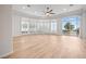 Bright living room with light wood flooring, ceiling fan, bay window, and sliding glass door leading to outdoor terrace at 2742 Darby Falls Dr, Las Vegas, NV 89134