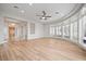 Large living room with bay windows, ceiling fan, and a view into entry featuring chandelier and wood door at 2742 Darby Falls Dr, Las Vegas, NV 89134