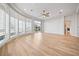Spacious living room features light wood flooring, ceiling fan, and curved window wall with views of the neighborhood at 2742 Darby Falls Dr, Las Vegas, NV 89134