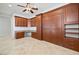 Bright home office with built-in desk and cabinets plus a Murphy bed, ceiling fan and tile flooring at 2742 Darby Falls Dr, Las Vegas, NV 89134