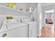 Functional laundry room with washer, dryer, storage shelf and view to the hall at 2753 Trickling Brook Ct, Las Vegas, NV 89156