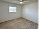 Empty bedroom features wood-look tile flooring, ceiling fan, and window at 2804 E Gowan Rd, North Las Vegas, NV 89030