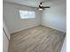 Well-lit bedroom with wood-look tile flooring, a ceiling fan, and a window view at 2804 E Gowan Rd, North Las Vegas, NV 89030