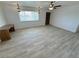 Bright living room featuring wood-look tile floors, modern ceiling fans, and ample natural light at 2804 E Gowan Rd, North Las Vegas, NV 89030