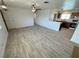 Open floor plan living room with wood-look tile, ceiling fan, and access to kitchen at 2804 E Gowan Rd, North Las Vegas, NV 89030