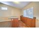 A bar area with tiled flooring, wood cabinets, an island and a large window allowing for ample natural light at 2809 Mountain Violet Ct, Las Vegas, NV 89108