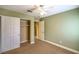 Green bedroom with closet, ceiling fan, neutral carpet, and door leading to adjacent room at 2809 Mountain Violet Ct, Las Vegas, NV 89108