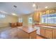 Kitchen area with tiled flooring, wooden cabinets, a sink, a kitchen island, and backyard access at 2809 Mountain Violet Ct, Las Vegas, NV 89108
