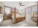 Spacious main bedroom with four-poster bed, neutral carpet, ceiling fan, and sun-drenched windows and doors at 2933 Red Springs Dr, Las Vegas, NV 89135