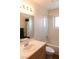 Clean, white tiled bathroom featuring a shower/tub combo and a large mirror above the sink at 3008 Blue Fin Cir, Las Vegas, NV 89128