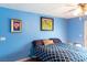 Bedroom boasts blue walls, natural light, and a comfy bed with patterned comforter at 3008 Blue Fin Cir, Las Vegas, NV 89128