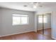 Bright bedroom featuring wood floors, a window and mirrored closet doors at 3008 Blue Fin Cir, Las Vegas, NV 89128
