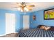 Bedroom featuring blue walls, ceiling fan, cozy bed, and artwork at 3008 Blue Fin Cir, Las Vegas, NV 89128