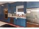This kitchen includes blue cabinets, stainless appliances, tile backsplash, granite countertops, and a window at 3008 Blue Fin Cir, Las Vegas, NV 89128