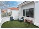 Cozy outdoor patio area with artificial turf, seating, white fence, and the home's exterior in the background at 3008 Blue Fin Cir, Las Vegas, NV 89128