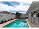 Sparkling swimming pool and hot tub in a backyard with a white pergola, fence, and desert landscaping at 3008 Blue Fin Cir, Las Vegas, NV 89128