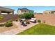 Backyard patio with outdoor seating, fire pit, grass, and landscaped gravel area at 3042 Echoed Rondel Ln, Henderson, NV 89044
