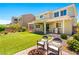 Backyard with artificial turf, outdoor seating, fire pit, and covered patio with grill at 3042 Echoed Rondel Ln, Henderson, NV 89044