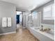 Bright bathroom with a glass enclosed shower and a soaking tub at 3042 Echoed Rondel Ln, Henderson, NV 89044