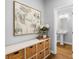 Stylish entryway with a decorative cabinet, artwork, and a glimpse into a clean, modern bathroom at 3042 Echoed Rondel Ln, Henderson, NV 89044