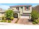 Charming two-story home featuring a brick driveway, an attached two-car garage, and a beautifully landscaped front yard at 3042 Echoed Rondel Ln, Henderson, NV 89044