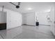 Epoxy-floored garage featuring built-in white storage cabinets, a door, and wall-mounted accessories at 3042 Echoed Rondel Ln, Henderson, NV 89044
