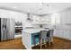Modern kitchen with white cabinets, stainless steel appliances, island with bar seating, and pendant lighting at 3042 Echoed Rondel Ln, Henderson, NV 89044