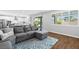 Inviting living room boasts a comfortable gray sectional, wood floors, and a view to the modern kitchen at 3042 Echoed Rondel Ln, Henderson, NV 89044