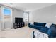 Spacious living room with a blue sectional sofa, TV, and large windows with white curtains at 3042 Echoed Rondel Ln, Henderson, NV 89044