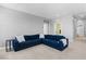 Comfortable living room featuring a blue sectional sofa, neutral carpet, and ample natural light at 3042 Echoed Rondel Ln, Henderson, NV 89044