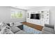 Bright living room featuring a gray sectional sofa, wood floors, and a built-in entertainment center at 3042 Echoed Rondel Ln, Henderson, NV 89044