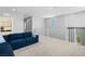 Open loft area with a blue sofa, neutral carpet, and bright natural light at 3042 Echoed Rondel Ln, Henderson, NV 89044