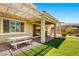 Covered patio with picnic table and barbecue grill overlooking a manicured backyard lawn at 3042 Echoed Rondel Ln, Henderson, NV 89044