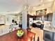 Open-concept kitchen with stainless steel appliances, dark cabinetry, and a dining area with chandelier at 3329 Hidden Ridge St, Las Vegas, NV 89129