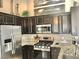 Modern kitchen features stainless steel appliances, granite countertops, and dark wood cabinets at 3329 Hidden Ridge St, Las Vegas, NV 89129