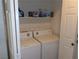 Convenient laundry area with a full-size washer, dryer, and storage shelves at 3329 Hidden Ridge St, Las Vegas, NV 89129