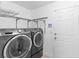 Efficient laundry room featuring modern washer and dryer units and wire shelving for storage at 356 Clark Dr, Henderson, NV 89074