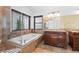Ensuite bathroom featuring a tub, dual vanities, tiled floor, and large window at 356 Clark Dr, Henderson, NV 89074