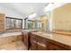 Primary bath with granite counters, dual sinks, soaking tub, glass shower, and large windows at 356 Clark Dr, Henderson, NV 89074