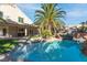Resort style backyard pool features a rock waterfall and beautifully landscaped yard with covered patio at 356 Clark Dr, Henderson, NV 89074