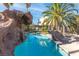 Beautiful backyard pool with rock features and tropical landscaping creating a private oasis for relaxation at 356 Clark Dr, Henderson, NV 89074