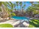 Stunning backyard pool area with rock waterfall feature and lush palm trees, perfect for outdoor relaxation and entertaining at 356 Clark Dr, Henderson, NV 89074